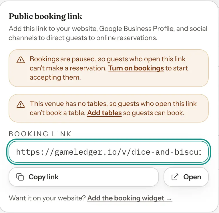 The Public booking link panel opened from Share booking link on the Bookings page, with two warnings, one that bookings are paused and one that the venue has no tables, above the booking link.